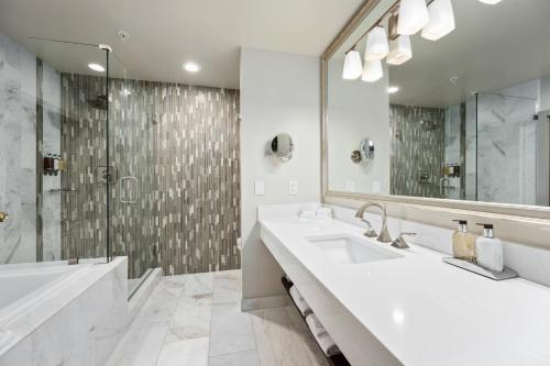 a bathroom with a tub and a sink and a shower at Hotel Bellwether on Bellingham Bay in Bellingham