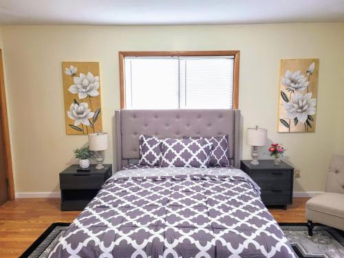 een slaapkamer met een bed en een raam met bloemen bij Nice big house with parking, fenced yard in Buffalo