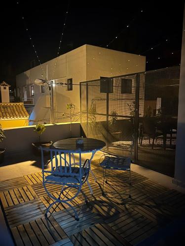 a table and two chairs on a patio at night at Plaza de la fuente Granadilla de Abona Tenerife sur Only Adults con terraza privada in Granadilla de Abona