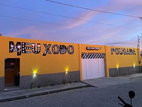 a yellow building with writing on the side of it at Meu Xodó Pousada in Piranhas