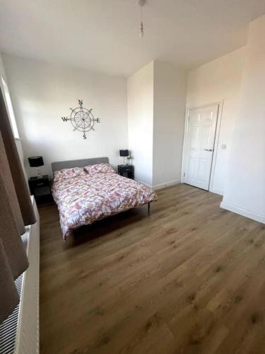 a bedroom with a bed and a wooden floor at Cosy 3 bedroom flat in Chatham in Chatham