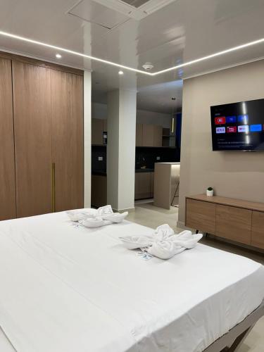 1 cama blanca grande en una habitación con TV en Hotel Amazonas Suite, Suite Presidencial en Nueva Loja