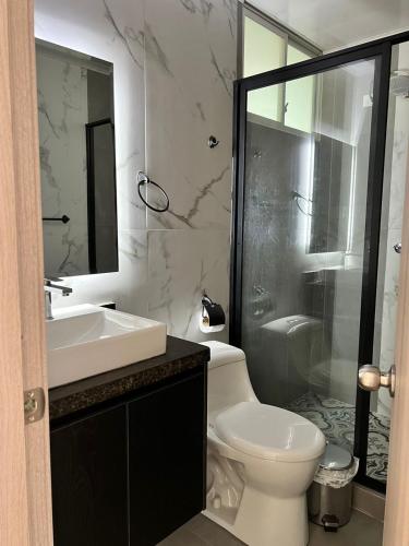a bathroom with a toilet and a sink and a shower at Hotel Amazonas Suite, Suite Presidencial in Nueva Loja
