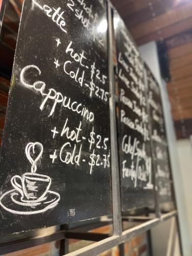 a chalk board with a cup of coffee on it at Rocky Cafe & Mini Apartment in Siem Reap