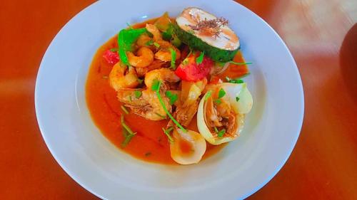 een bord met garnalen en groenten op een tafel bij Splanada poilon in Assomada