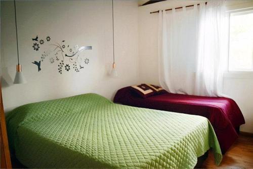a bedroom with two beds and a window at Brisas de Geranio in Capilla del Monte