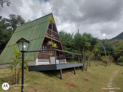 a small house with a green roof and a street light at Pousada nossa senhora in Aiuruoca