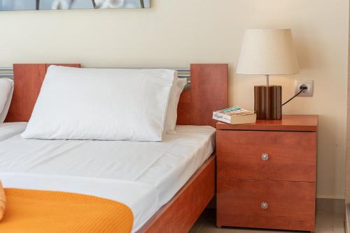 a bedroom with a bed and a nightstand with a lamp at Arte Villa Nefeli Apartment in Sami