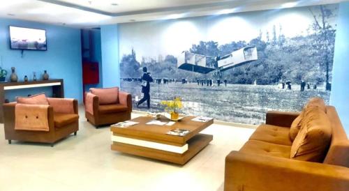a living room with two couches and a large painting on the wall at Flats Bela Vista para o Mar in Macaé