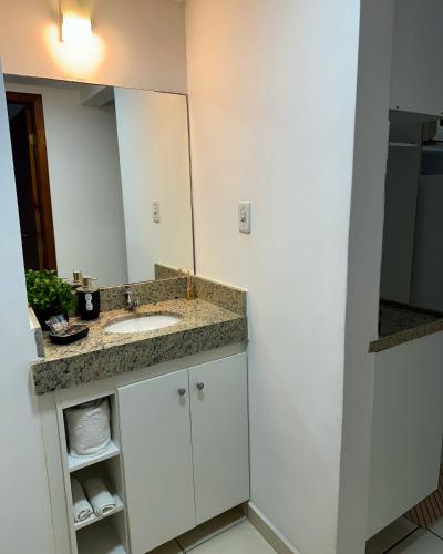 a bathroom with a sink and a mirror at Flats Bela Vista para o Mar in Macaé