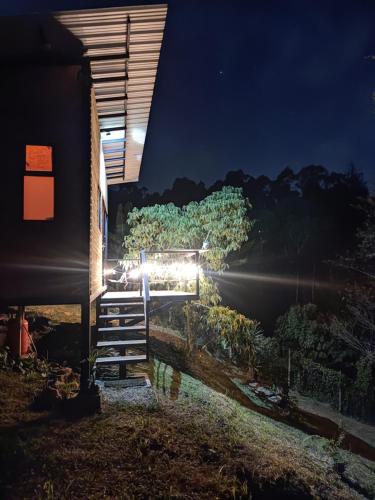 een trap die 's nachts naar een huis leidt bij cabaña madera in Guarne