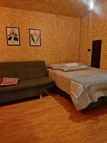 ein Schlafzimmer mit einem Bett und einem Sofa in der Unterkunft cabaña madera in Guarne