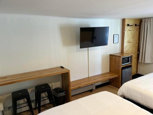 a hotel room with two beds and a flat screen tv at Happy Bear Motel in Killington