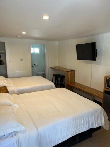 Habitación de hotel con 2 camas y TV de pantalla plana. en Happy Bear Motel, en Killington