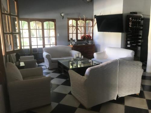 uma sala de estar com mobiliário branco e um piso em xadrez em Posada Pinar De Besares em Chacras de Coria