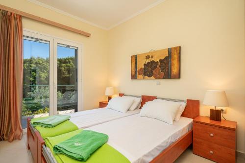 sypialnia z 2 łóżkami i oknem w obiekcie Arte Villa Nefeli Apartment w mieście Sami