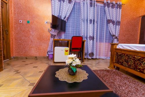 a living room with a table and a tv at Kobby Keach K Hotel in Kumasi