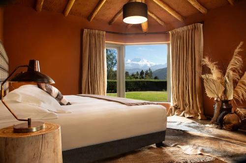 um quarto com uma cama e uma grande janela em Cuesta Serena Boutique Hotel em Huaraz
