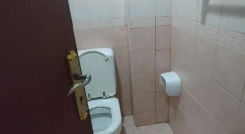 a bathroom with a white toilet in a stall at Biggest Room in Sharjah in Sharjah