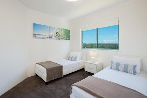 a bedroom with two beds and a window at The Waterford on Main Beach in Gold Coast