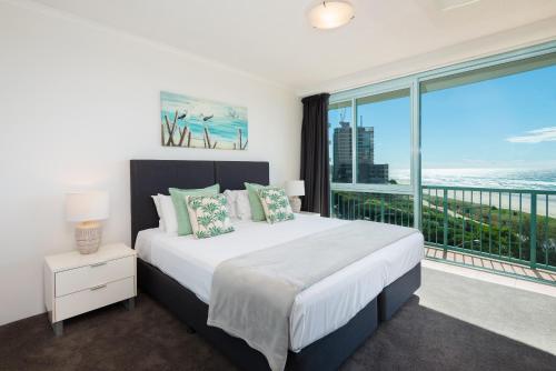 a bedroom with a large bed and a large window at The Waterford on Main Beach in Gold Coast