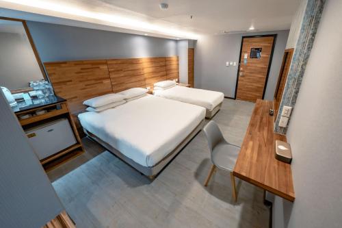 a hotel room with a bed and a table and a mirror at 雲沐行旅 Hotel Cloud Arena-Daan in Taipei