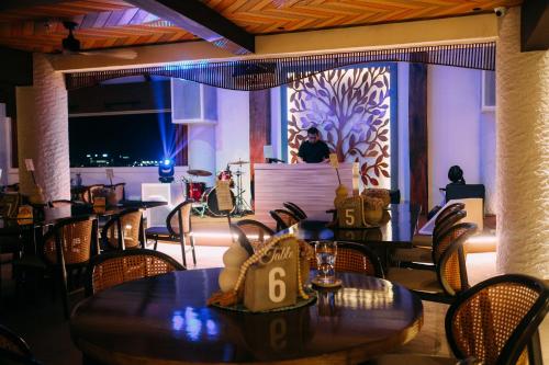 a restaurant with tables and chairs and a person in the background at Azzurro Hotel in Angeles