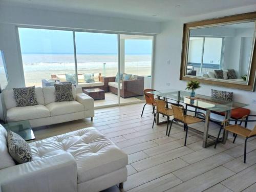 sala de estar con sofá blanco y mesa de cristal en 202 Urban Beach, en Lurín