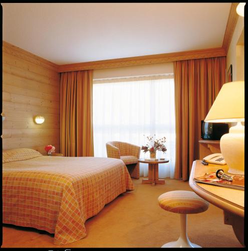 a hotel room with a bed and a window at Hotel le Chalet in Gresse-en-Vercors