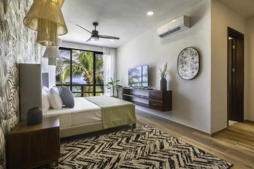 a bedroom with a bed and a large window at Beachfront Hotel La Palapa - Adults Only in Holbox Island