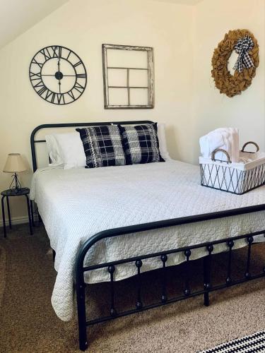 a bedroom with a bed with a clock on the wall at The Founders Suite at The Historic Kanab Inn in Kanab