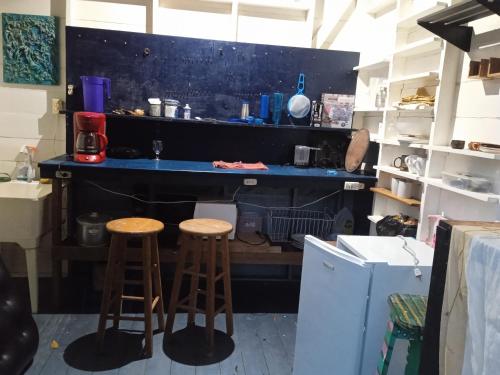 una cocina con 2 taburetes y una barra en casa de huéspedes selvatica, en Utila