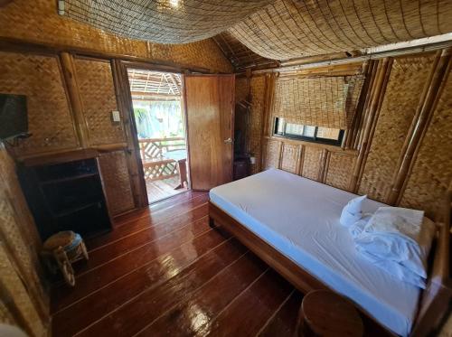 Schlafzimmer mit einem Bett und Holzboden in der Unterkunft NATIVO D' KUBO in San Vicente