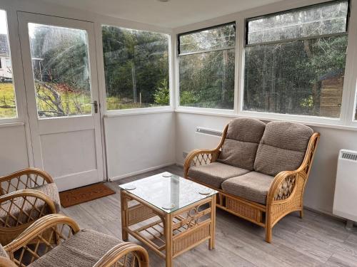 a living room with a couch and a table and windows at Shared House in Inverness in Inverness