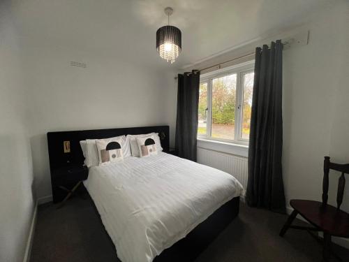 a bedroom with a bed with white sheets and a window at Shared House in central location Inverness in Inverness