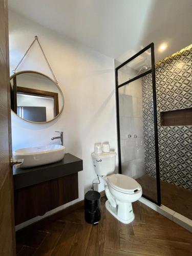 een badkamer met een toilet, een wastafel en een spiegel bij Departamento las huertas in Cuauhtémoc