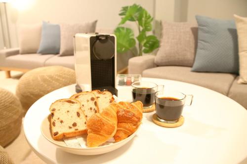 a plate of bread and croissants on a table with a laptop at Casa Stella 3 Sagittarius by Liaison in Osaka