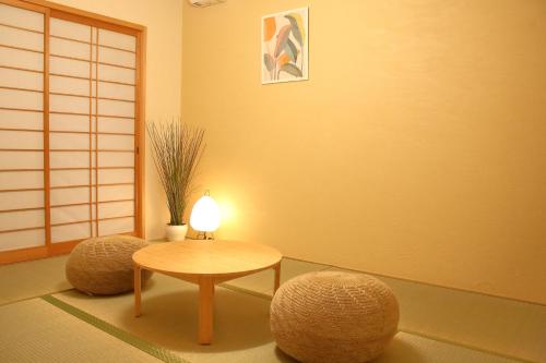 a room with a table and stools with a lamp at Casa Stella 3 Sagittarius by Liaison in Osaka