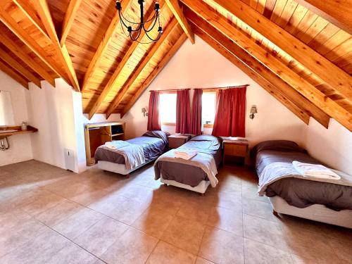 a room with three beds and a wooden ceiling at Enzojo-caviahue in Caviahue
