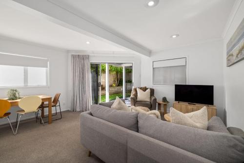 a living room with a couch and a table at Seaside Studio with Fully equipped kitchen and laundry in Mount Maunganui