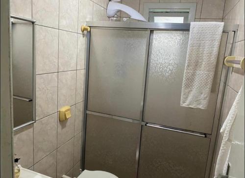 een douche met een glazen deur in de badkamer bij Casa de férias! in Capão da Canoa