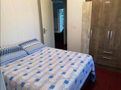 um quarto com uma cama e um armário de madeira em Casa de férias! em Capão da Canoa