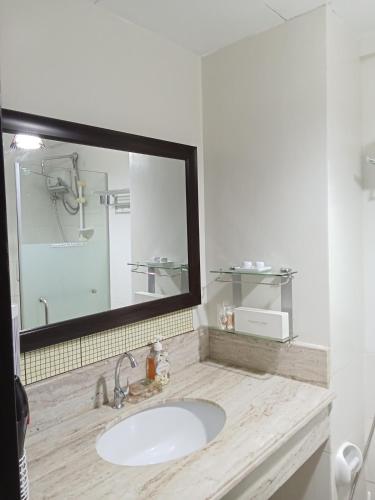 łazienka z umywalką i dużym lustrem w obiekcie Rhapsody Residences Mandolin bldg w mieście Manila