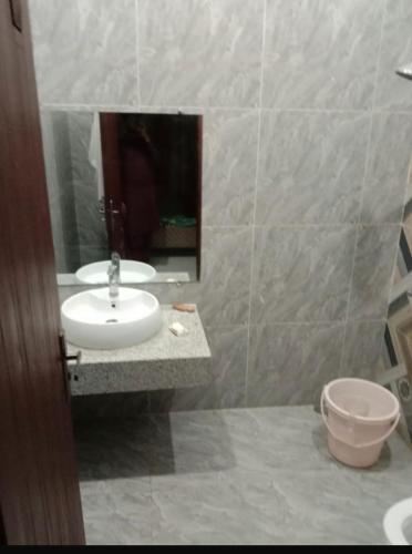 W łazience znajduje się umywalka, lustro i toaleta. w obiekcie Bahria town karachi w mieście Karaczi