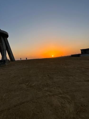 a sunset on the beach with the sun setting at Bahria town karachi in Karachi