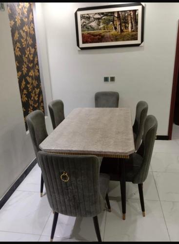 a dining room table and chairs with a table and a picture at Bahria town karachi in Karachi