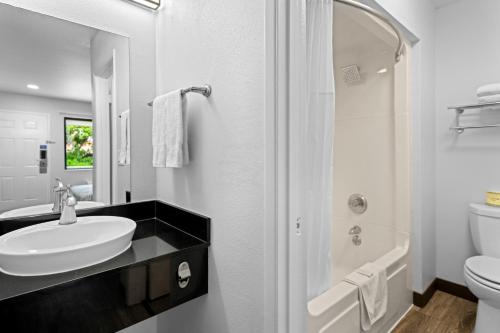 Baño blanco con lavabo y aseo en Motel 6-Monterey, CA en Monterey