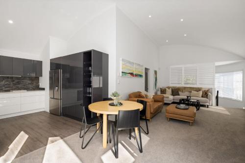 a kitchen and living room with a table and a couch at Seaside Bliss Your Coastal Haven in Mount Maunganui