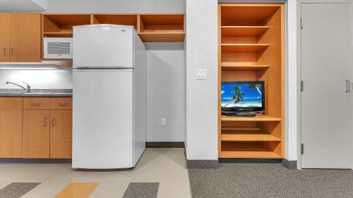 a white refrigerator in a kitchen with a tv at Residence & Conference Centre - London in London