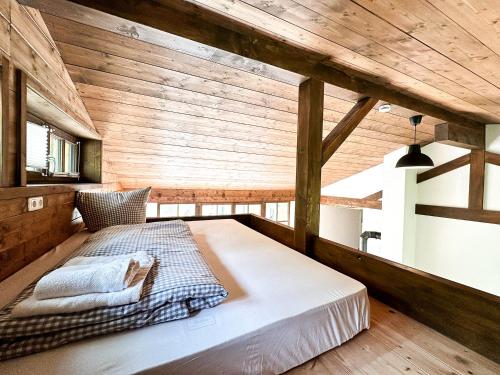 Cama en habitación con paredes de madera en Vogelnest en Oberstaufen